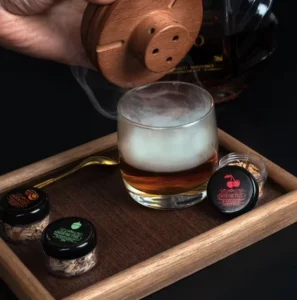 Viskija un citu dzērienu kūpināšanas komplekts ar tumši brūnu, apaļu kūpinātavu un 5 aromātiem